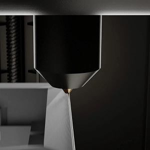 Close-up of an FDM 3D printer nozzle laying down filament